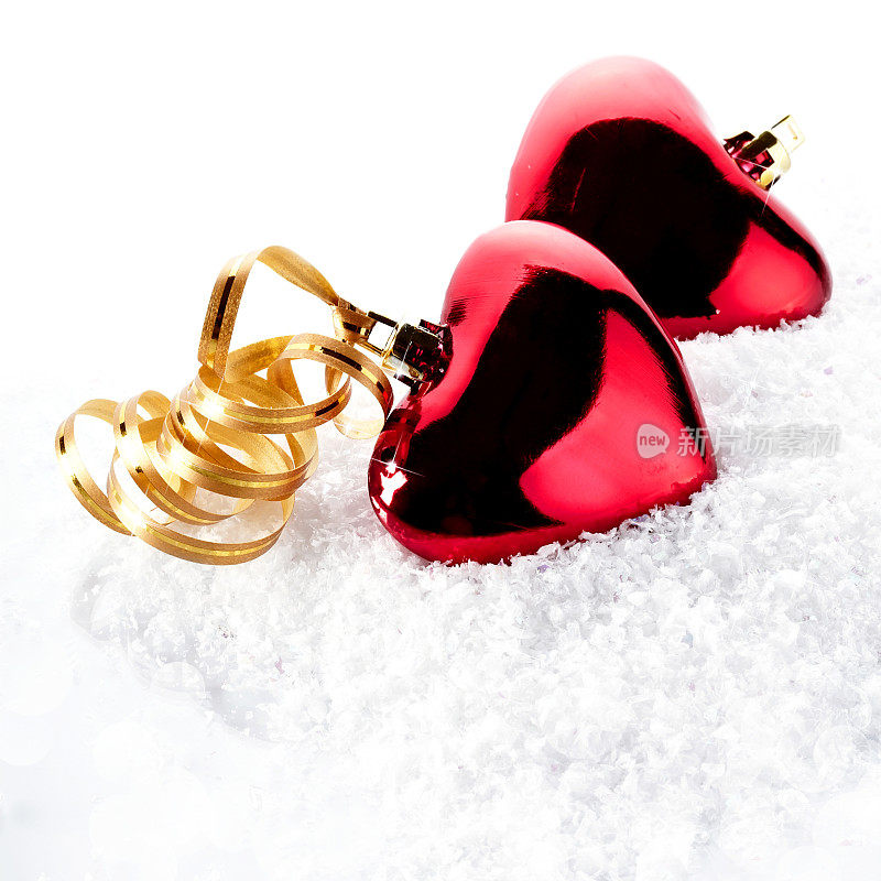 两颗红心用金色胶带粘在雪地上
