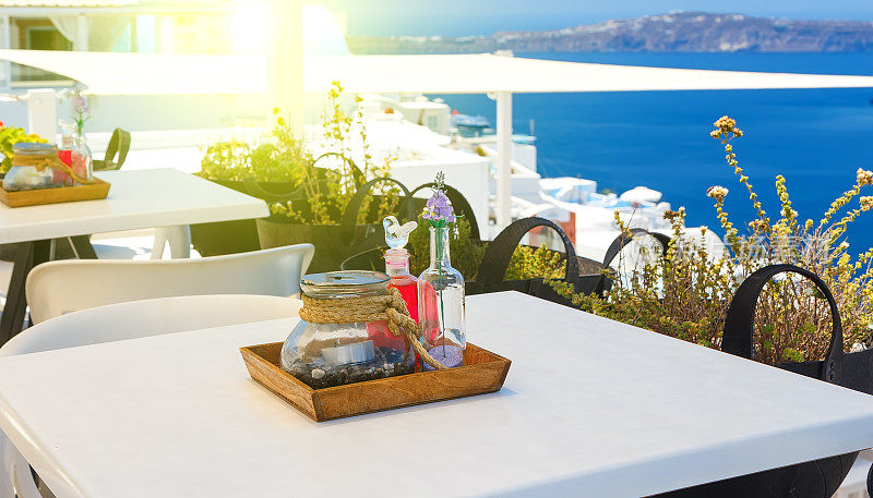 在餐桌上用餐，欣赏希腊圣托里尼火山口和大海的景色
