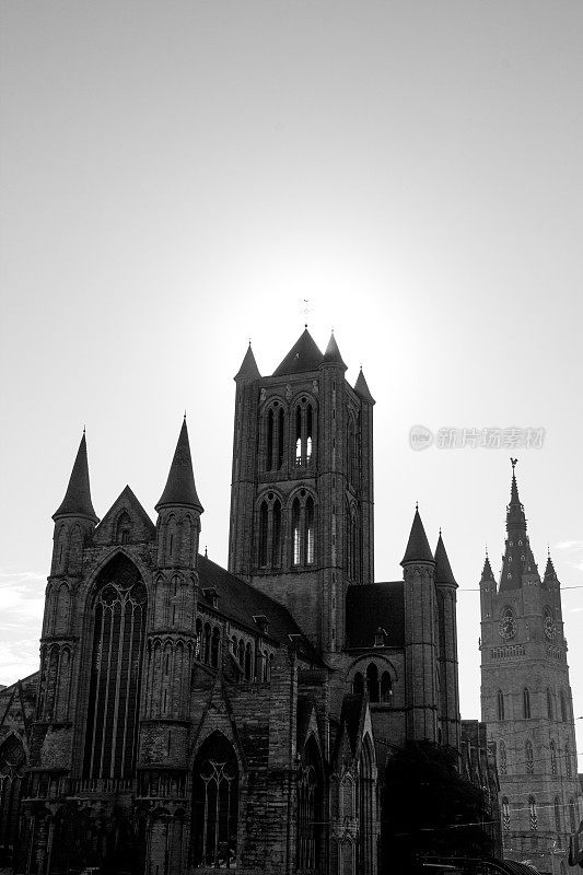 日落时分圣巴沃教堂和钟楼的黑白照片，根特