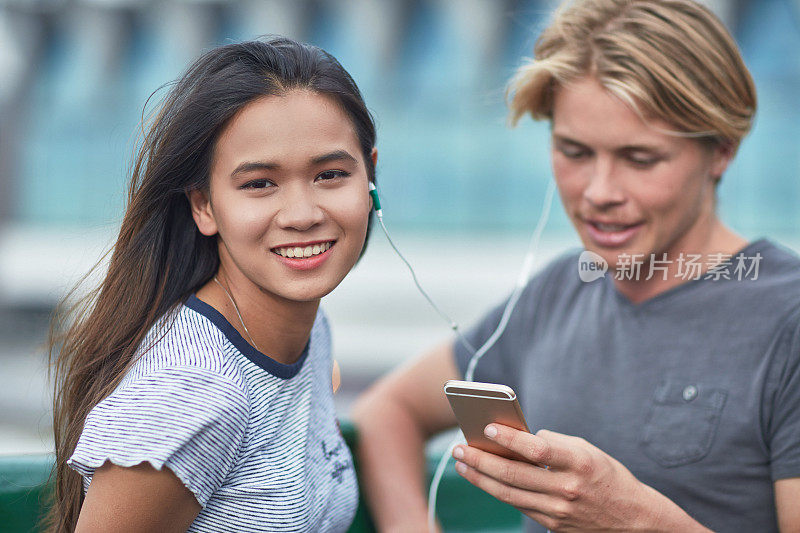 女人听音乐，男人戴耳机