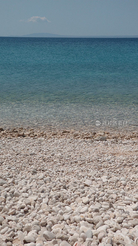 卵石滩，绿松石海和夏天阳光灿烂的天空