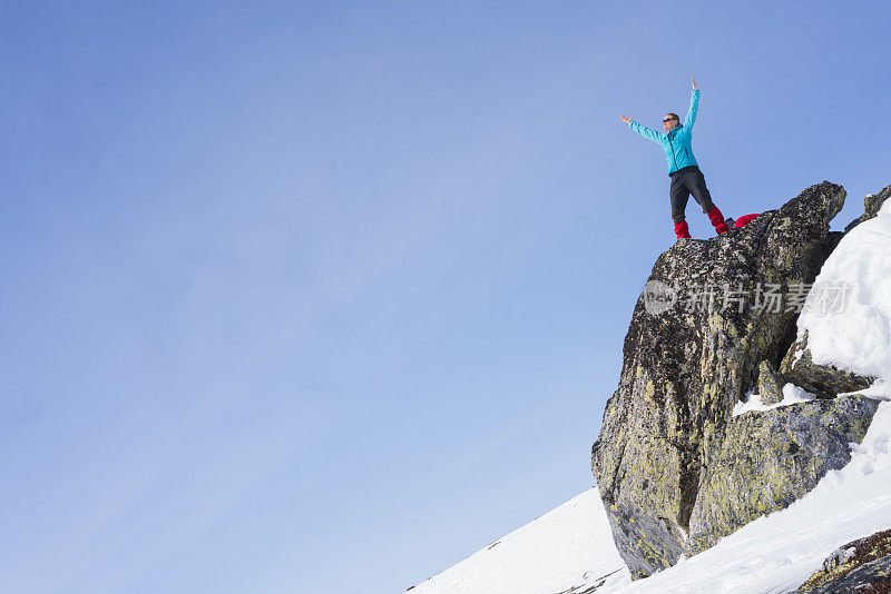 黄金和光荣，资深女性，不列颠哥伦比亚省滑雪者在挪威哈当厄飞机的荒野岩石上拍照