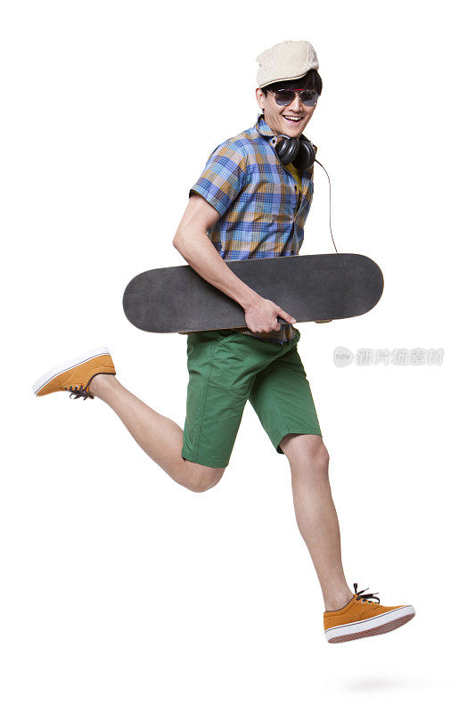 拿着滑板跳跃的年轻男士