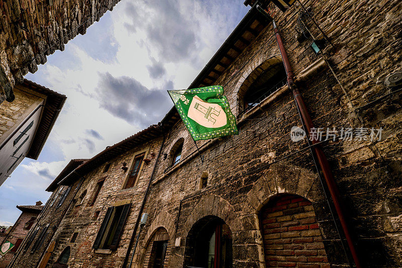 翁布里亚(Umbria)中世纪城镇古比奥(Gubbio)一条古老的石头小巷里飘扬着Contrada的旗帜