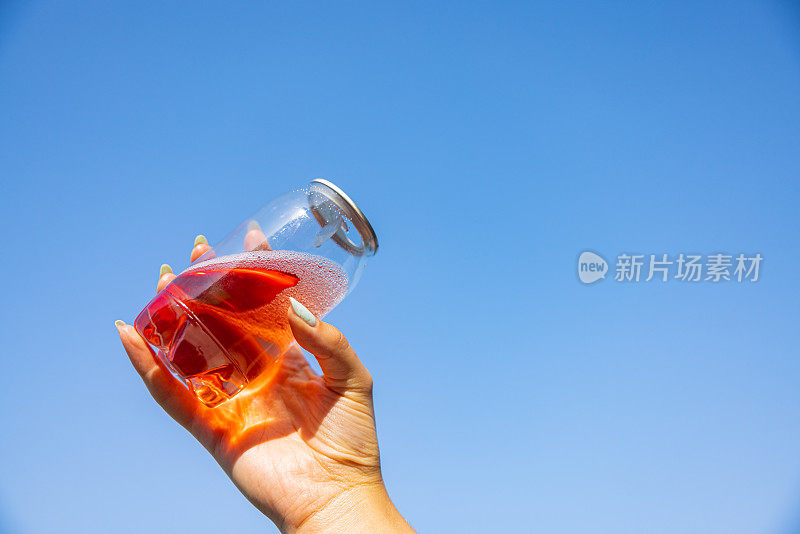 不认识的女人拿着装着冰茶的塑料罐