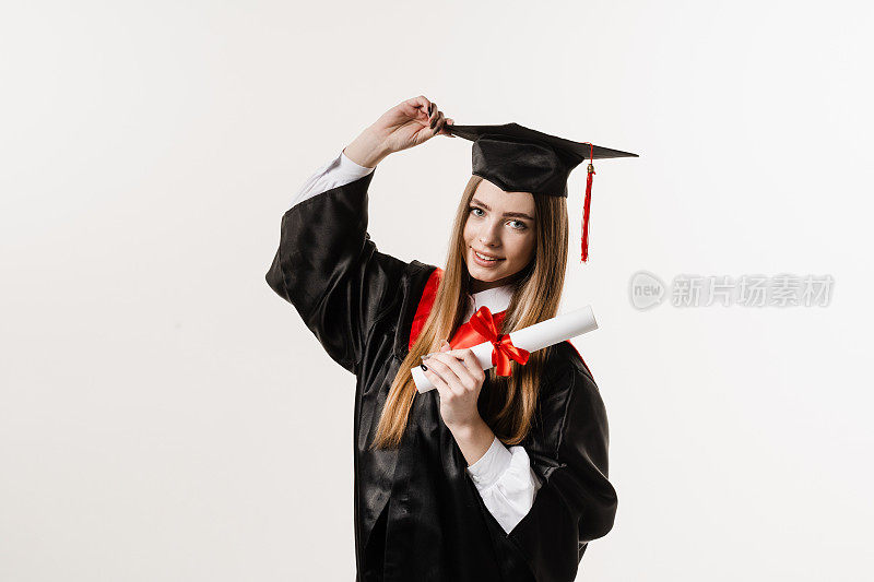 女研究生从大学毕业并获得硕士学位。毕业典礼。快乐的毕业女孩微笑着，手里拿着白色背景的荣誉证书。