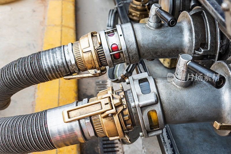 安装在油罐车口连接排放软管的装置，在背景中排放正常柴油(柴油a)和补贴柴油(柴油B或红色)。