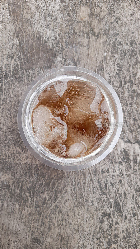 甜冰茶在玻璃顶视图与街道纹理背景。