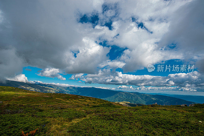 在一个阳光明媚的夏日里，有美丽的山峦和岩石景观。