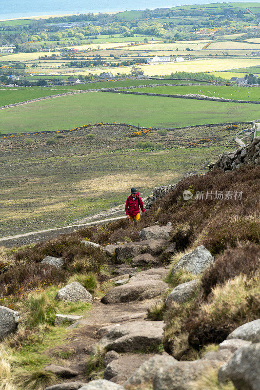一名女子在北爱尔兰斯利夫宾尼山徒步旅行的垂直镜头