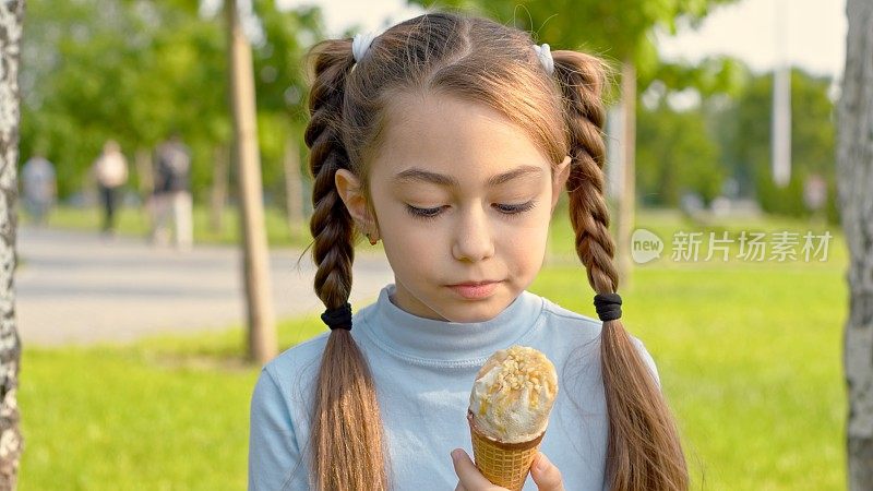 女孩看着冰淇淋，想要吃掉它