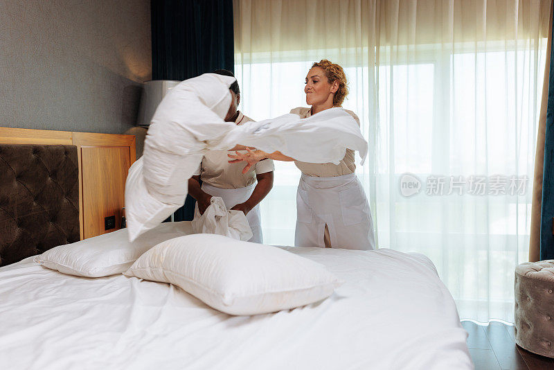 愤怒的白人女佣在和同事打扫客房时扔枕头