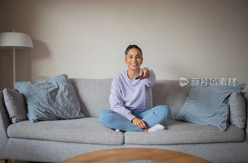 女人在家里欣赏她最喜欢的电视节目