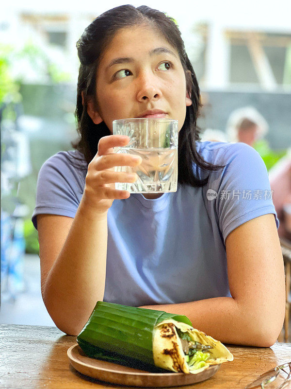 多种族年轻女子在巴厘岛吃素食茄子香蒜沙司包