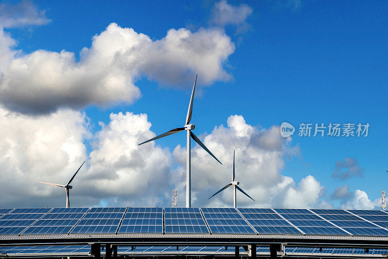 平原地区的太阳能发电站，巨大的蓝色太阳能电池板和巨大的风力涡轮机。