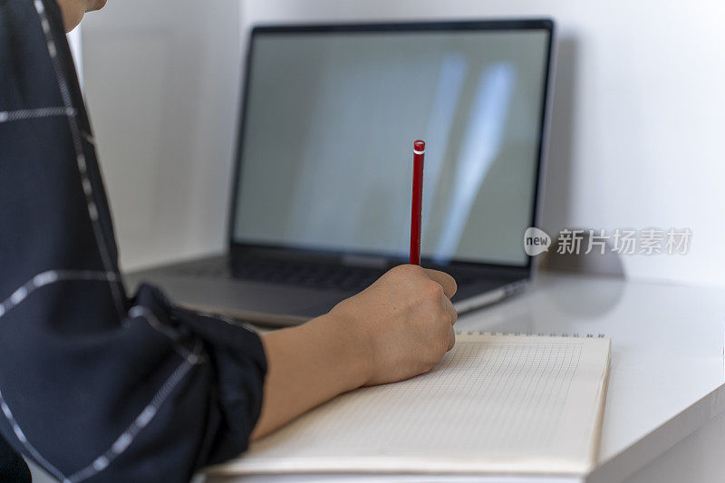 一个正在学习的女孩。小学生用电脑学习。女学生在家做作业。回到学校。