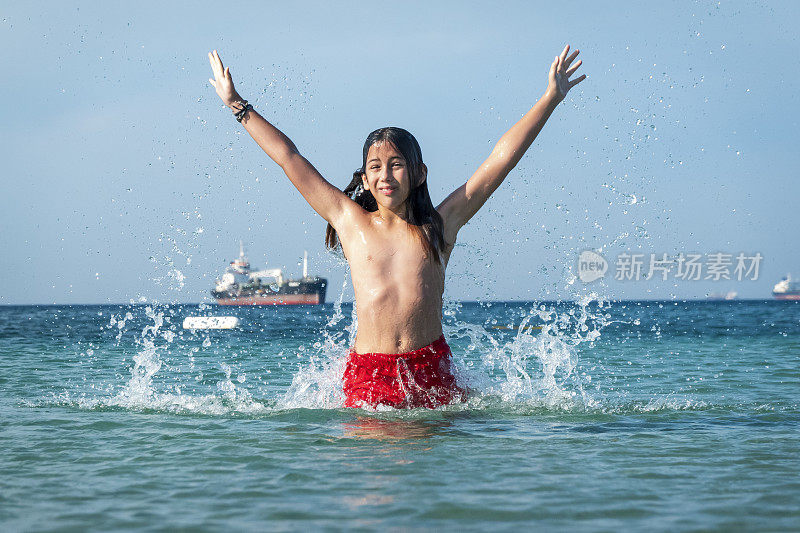 他用手在海里泼水。一个夏天的早晨。忒涅多斯岛。爱琴海北部，12岁的帅哥。长头发的