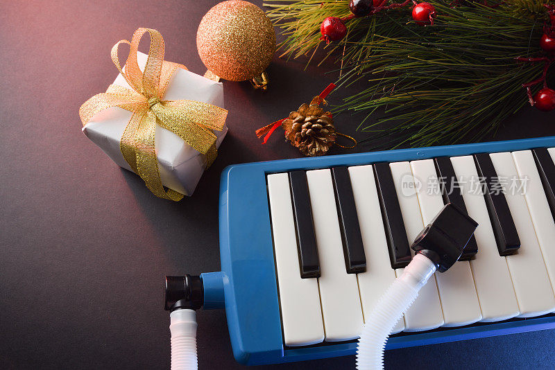 黑色的桌子上放着蓝色的旋律琴，上面有礼物和圣诞装饰