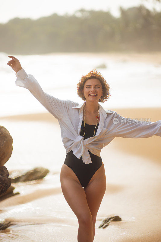 比基尼无忧无虑的微笑女人在海滩放松时的假期快乐