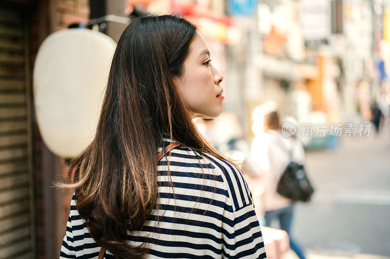 前往东京和大阪市旅游的亚洲女游客四处走走，她对这次旅行感到很开心