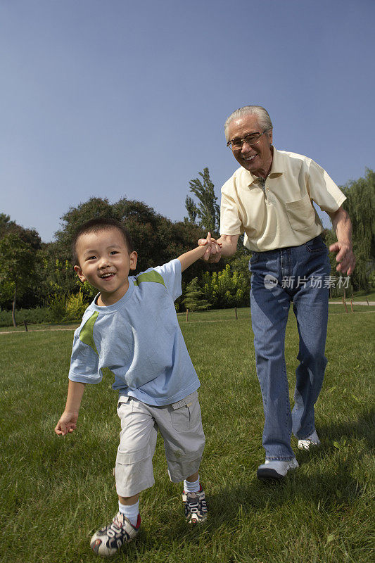 爷爷和孙子手牵手散步