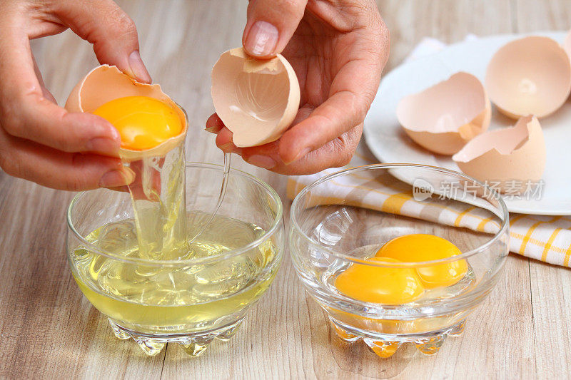 女人用手打碎鸡蛋，把蛋白和蛋黄分开