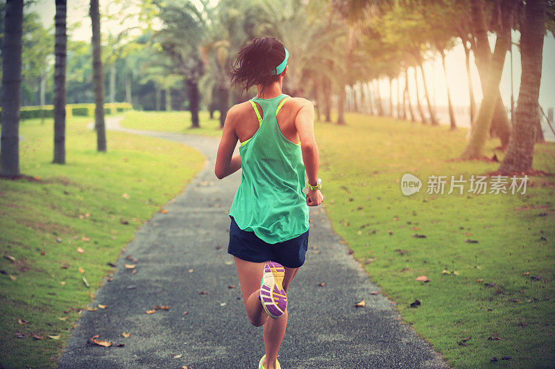 年轻的健身运动女性跑步热带公园小径