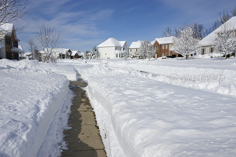 大雪在一个社区堆积，人行道清理