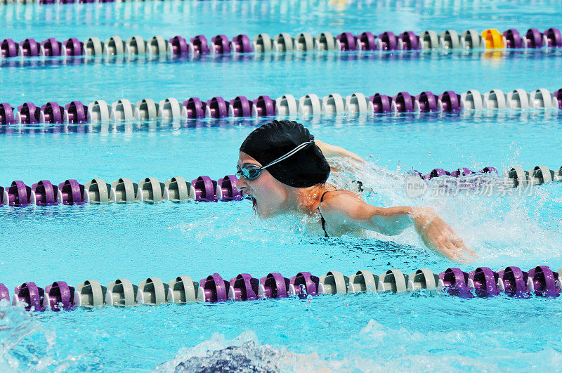小女孩运动员蝶泳游泳比赛在游泳池