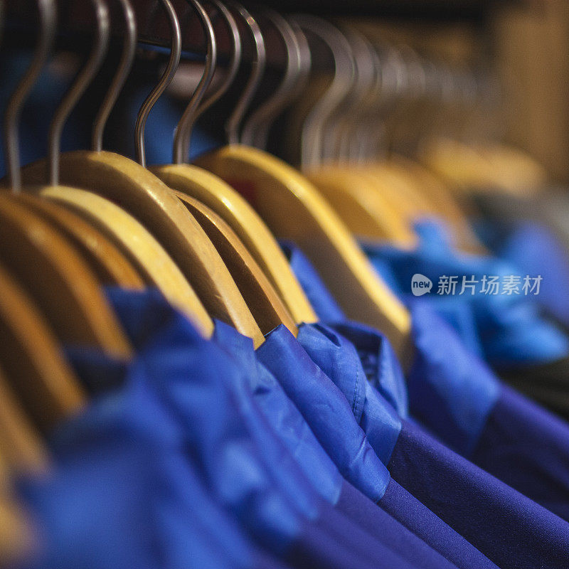近距离拍摄的蓝色衬衫与衣架上的衣架。