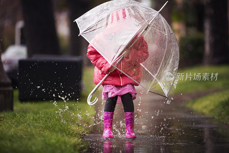 小女孩在加州的大雨中玩耍。