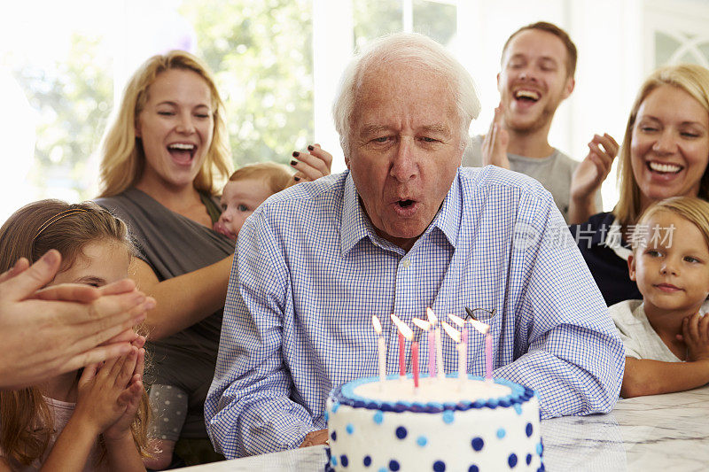爷爷在家庭聚会上吹灭生日蛋糕蜡烛