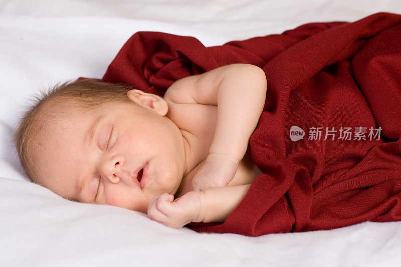红毯子里的婴儿睡着了