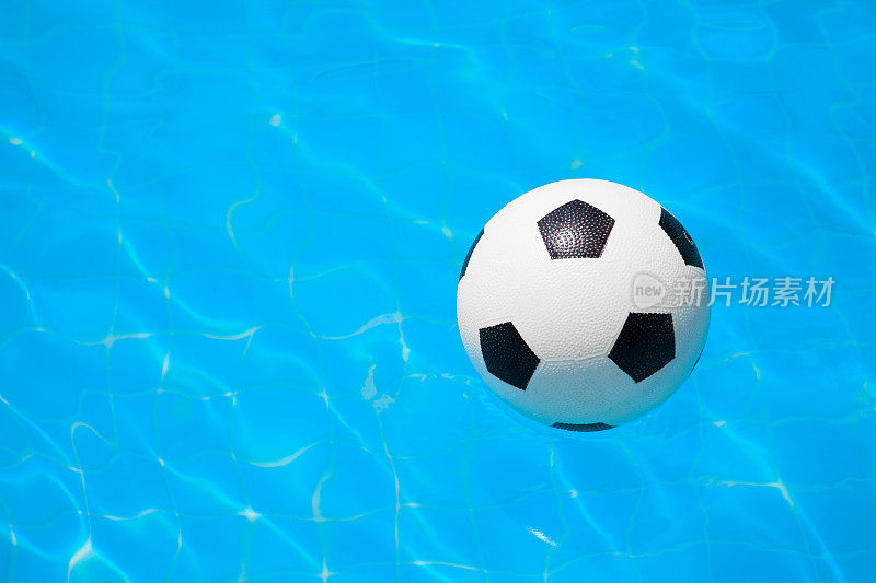 足球漂浮在游泳池的水面上