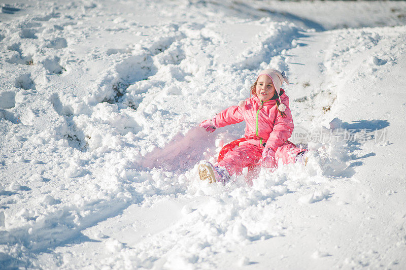 孩子在雪地上滑倒了