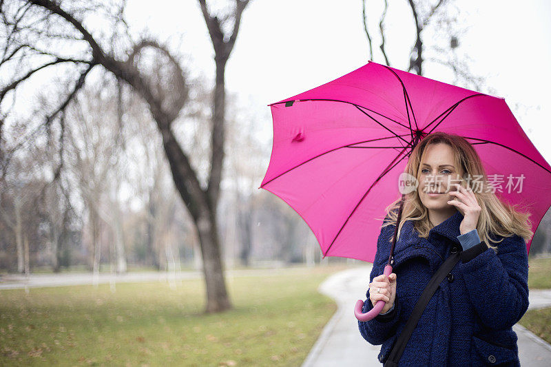 年轻女子与手机在雨天