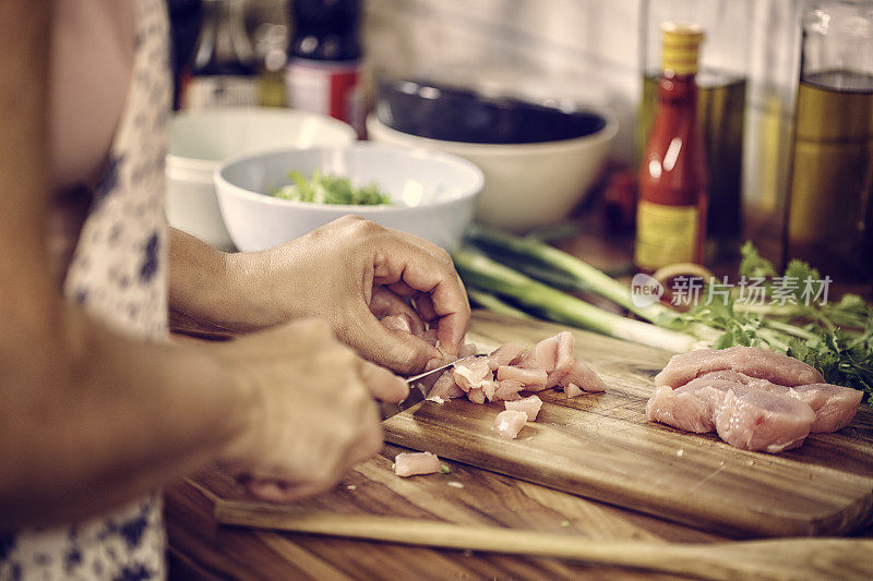 在炒饭的砧板上切鸡胸肉