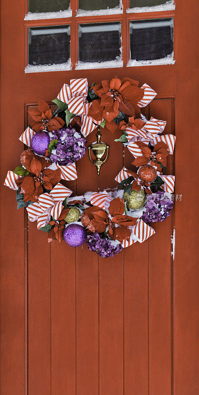 雪红色的圣诞门上挂着花环