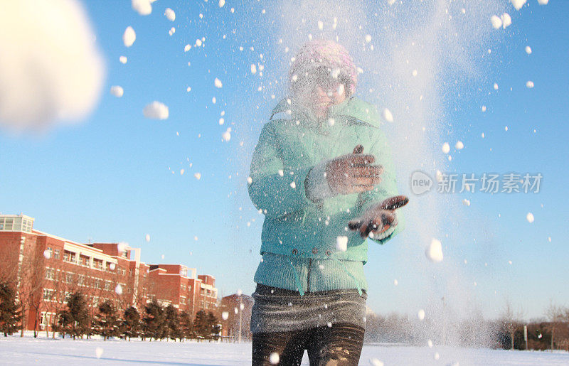 年轻的亚洲女孩在打雪仗