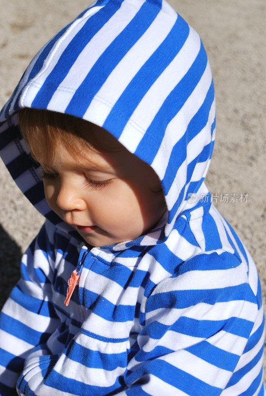 一个可爱的白人婴儿的肖像穿着脱衣连帽衬衫。