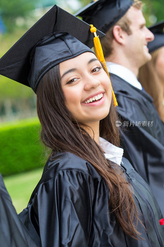 西班牙裔大学毕业生在毕业典礼上戴着学士帽和学士服