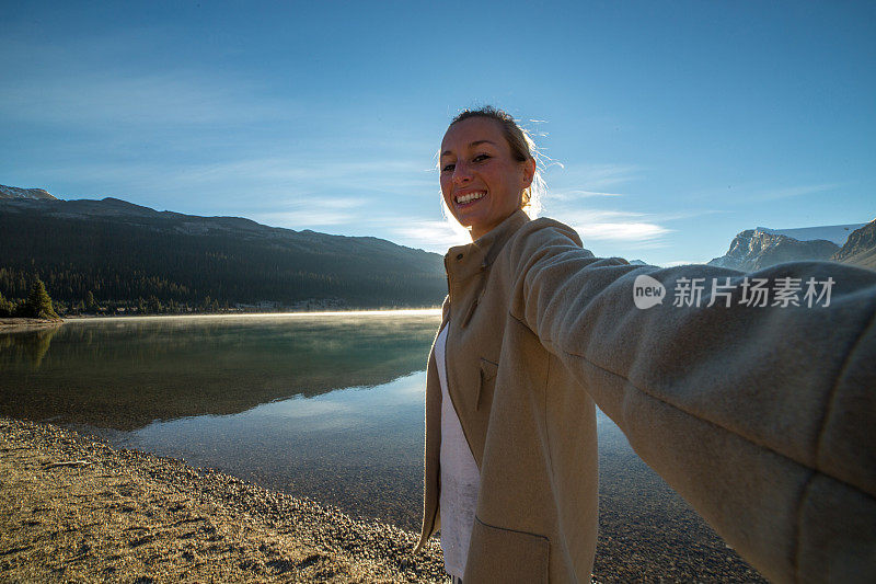 年轻女子自拍与惊人的湖山风景