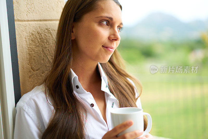 拿着杯子往外看的女人