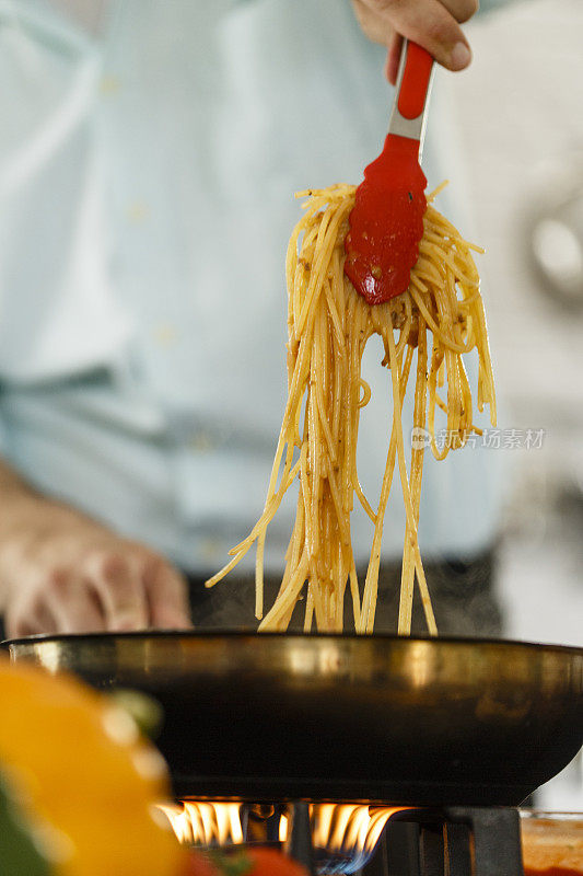 厨师将煮好的意面与肉酱混合