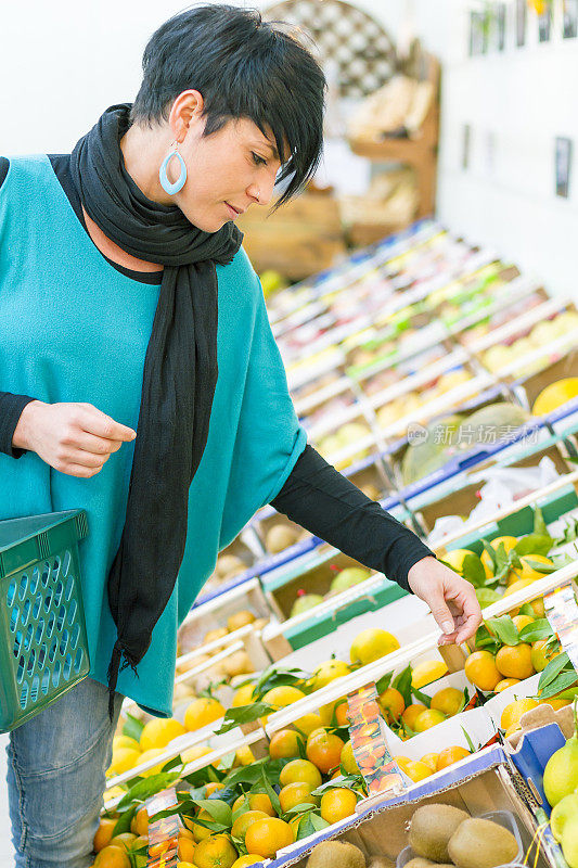 年轻女子在超市挑选水果