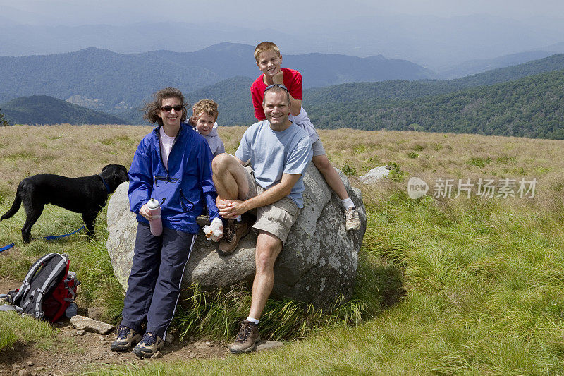 肖像，四口之家和狗，草地山顶徒步