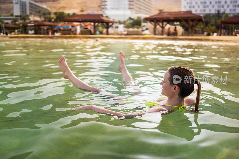 夏日里，年轻女子在死海中漂浮。