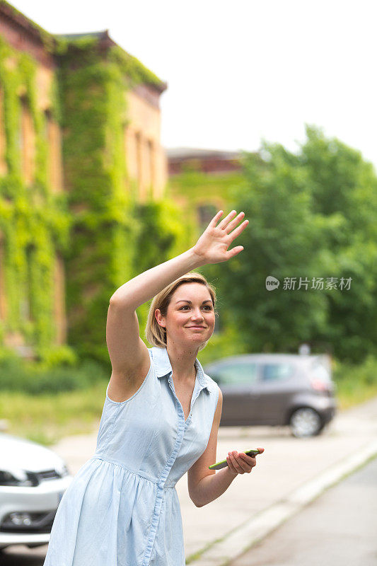 年轻女子拿着手机找出租车