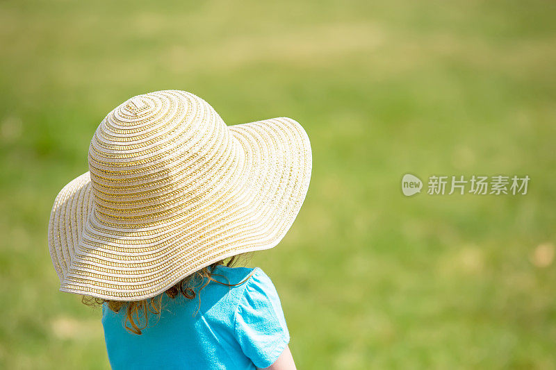 戴着太阳帽的小女孩与绿草复制空间