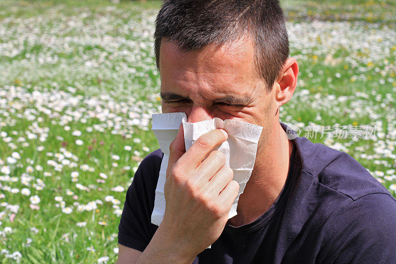 花粉过敏,春天。男人在纸巾里打喷嚏